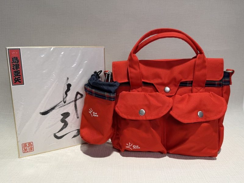 「SINGALONG Bag & Mannerpouch red」と直筆サイン色紙